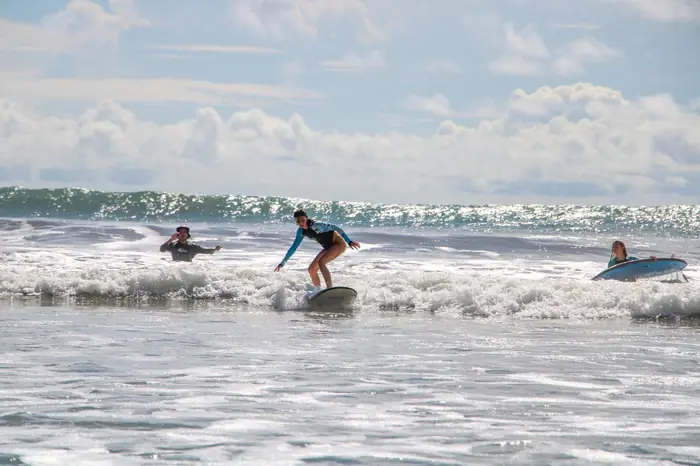 A beginner standing up on her board in the whitewater