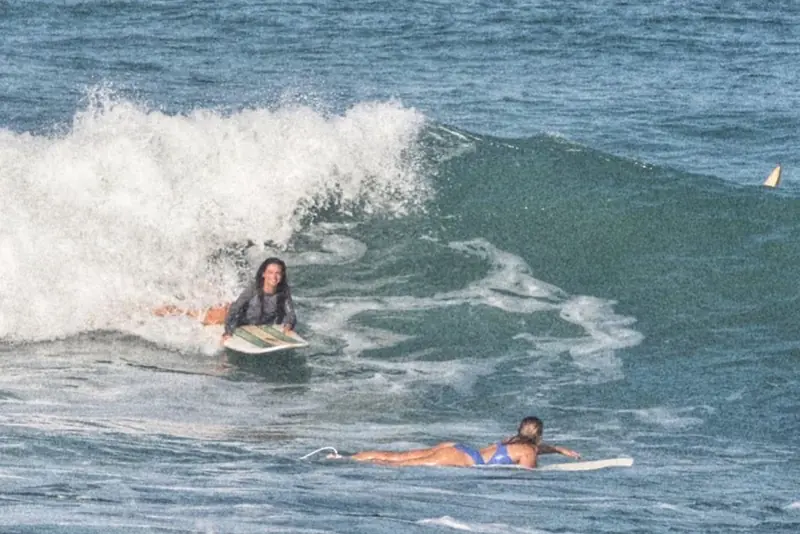 Two surfers paddling next to breaking whitewater in Santa Teresa