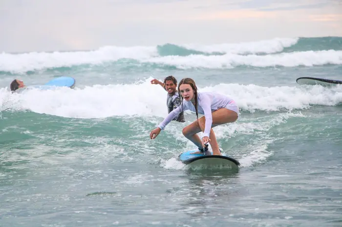 Weyser cheering as his student stands up on a wave